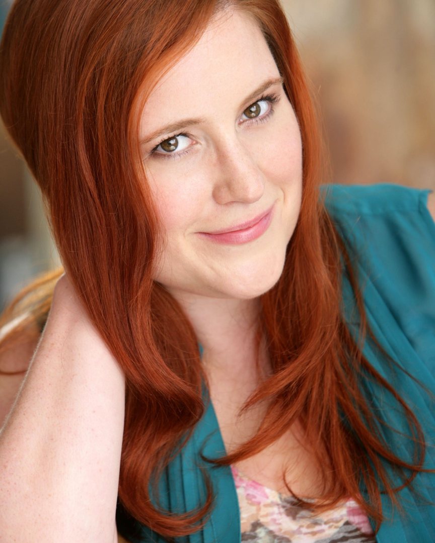 Courtney Freed, smiling at the camera, red hair, teal blouse